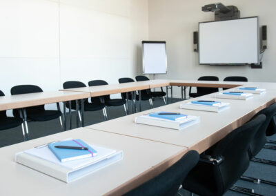 großer Seminarraum mit U-förmiger Tafel, Bestuhlung, Tageslicht, WLAN, Beamer, Schulungsunterlagen, Smart Board und Flip Chart